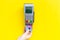 Pay by payment terminal. Woman`s hand inserts credit card to terminal on yellow background top view copy space