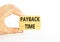 Payback time symbol. Concept words Payback time on wooden blocks. Beautiful white table white background. Businessman hand.