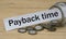 PAYBACK TIME words on a white strip of paper with a can of money