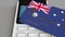 Payment or POS terminal with credit card featuring flag of Australia. Australian retail commerce or banking system