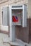 A payphone booth on a city street. Landline telephone