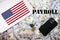 Payroll concept. USA flag, dollar money with keys, laptop and phone background