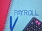 Payroll word on blue paper with calculator and pen