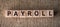 PAYROLL word written on wooden blocks on a brown background