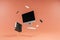 Pc, keyboard, mouse, display, binder and office supplies floating in the air orange background; business work productivity and