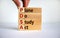 PDSA, plan do study act symbol. Businessman hand. Wooden cubes and blocks with words `PDSA, plan do study act`. Beautiful white