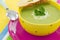 Pea cream soup with parsley and croutons, on pink plate