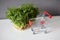 Pea shoots and empty shopping cart, microgreen sprouts on white table on gray wall background