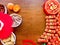 A peace blossom shaped candy tray and the firecracker decorations on wooden brown background for lunar new year.