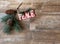 `Peace` ornament with pine sprig and cones on wood background