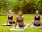 Peaceful Asian woman with her friends practicing outdoor group yoga at park