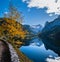 Peaceful autumn Alps mountain lake. Gosauseen or Vorderer Gosausee lake, Upper Austria. Dachstein summit and glacier in far