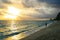 Peaceful beach walk on the sunset after tropical storm when shin sun rays opening the dark dramatic cloudy sky