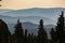 Peaceful, beautiful view of Cascade Mountain range framed by pine trees at sunset