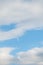 Peaceful blue sky with white clouds and a half moon, as a nature background