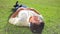 Peaceful brunette man lying on the grass while listening to music