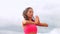 Peaceful brunette practicing yoga on the beach