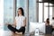 Peaceful businesswoman practice yoga sitting on table in office