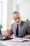 Peaceful concentrated old man in office costume inspecting information