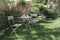 Peaceful, cozy garden corner with a pastel mint table and white hydrangea flowers. Gardening - french style, romantic nook