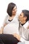 Peaceful Dreaming Caucasian Couple with Pregnant Woman Interacting While Sitting Embraced Against White Background