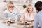 Peaceful elderly couple relishing dinner with their kid at home