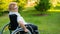 Peaceful elderly woman sitting in a wheelchair on a walk outdoors.
