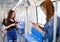 Peaceful ethnic female leaning on handrail and messaging on mobile phone while riding modern train, Concept for city life of