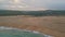 Peaceful evening seascape drone view. Foamy sea water rolling to sand seashore