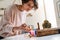 Peaceful girl lighting candles at home shrine indoors