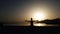 Peaceful girl sitting in yoga pose at sunset by the sea