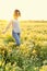Peaceful happy woman strolling among a field of wild flowers and grasses