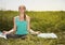 Peaceful healthy fit blond young woman meditating on the nature