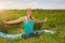 Peaceful healthy fit blond young woman meditating on the nature