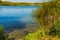 Peaceful landscape with blue lake,  rushes and marsh plants at the edge of the lake