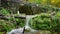 Peaceful landscape of a waterfall and an Ancient Bridge. Idyllic nature scene for meditation.