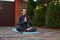 Peaceful man athlete, a yogi meditating in lotus pose, sitting barefoot on a fitness mat. Yoga practice. Mindfulness