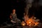 Peaceful mature man, tourist meditating while sitting near campfire and cooking dinner outdoors in forest at night