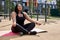 Peaceful mixed race woman in sport clothes sitting in lotus position yoga mat