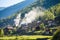 a peaceful mountain village with smoke wafting from chimneys