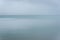 Peaceful nature background, calm Naknek Lake water meets foggy background, Katmai National Park, Alaska, USA