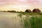 Peaceful nature at the Lake FertÅ‘ in Hungary with wooden pier bungalows cabins on the lake and straw in the water at