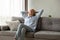 Peaceful older woman sitting on couch, relaxing at home