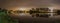 Peaceful panoramic view of river and trees backlit by Amsterdam city lights