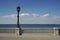 Peaceful scene with decorated street lamp and white handrail on the seaside in the Spanish city of Cadiz next to the sea