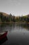 Peaceful scene featuring small boat on the tranquil shore of a lake