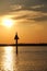 Peaceful scene at sunset, with marker guiding boats and bird perched on top