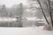 peaceful and serene winter landscape with snow-covered trees, a peaceful pond, and a touch of holiday spirit