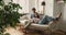 Peaceful serene young couple cuddling on cozy sofa chatting smiling