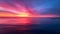 A peaceful stillness envelopes the ocean as the horizon is transformed into a canvas of vivid hues. The sky seems to be
